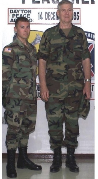 A young soldier in camouflage standing beside General Richard B. Myers in front of a Peacekeeper backdrop marked Dayton Peace Accord, 14 December 1995